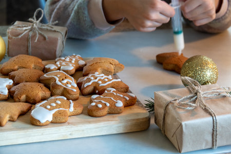 Children's hands make New Year's gingerbread cookies on a wooden table. New Year and Christmas...