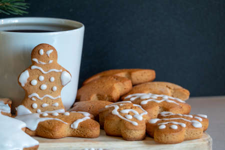 Happy New Year's set of gingerbread from ginger biscuits man glazed sugar icing decoration on black background, minimal seasonal pandemic winter holiday bannerの写真素材
