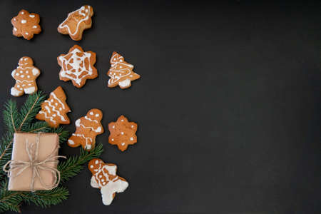 Happy New Year's set of gingerbread from ginger biscuits man glazed sugar icing decoration on black background, minimal seasonal pandemic winter holiday bannerの写真素材
