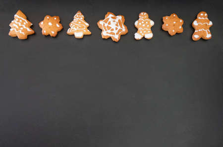 Happy New Year's set of gingerbread from ginger biscuits man glazed sugar icing decoration on black background, minimal seasonal pandemic winter holiday bannerの写真素材
