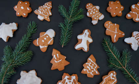 Happy New Year's set of gingerbread from ginger biscuits man glazed sugar icing decoration on black background, minimal seasonal pandemic winter holiday bannerの写真素材