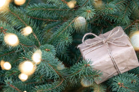 Photo of gift boxes under Christmas tree, New Year home decorations, wrapping of Santa presents, festive fir tree decorated with garland, baubles and angels, traditional celebrationの写真素材
