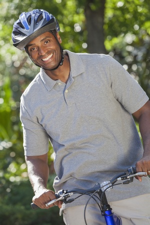 An African American man riding bicycle in the summerの写真素材