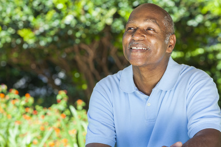 A happy senior African American man in his sixties outside smiling.