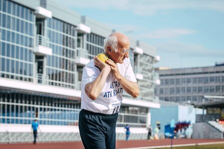 Chelyabinsk, Russia - August 28, 2015:  old man shot put during championship of Russia on track and field athletics among the elderly, Chelyabinsk, Russia - August 28, 2015のeditorial素材