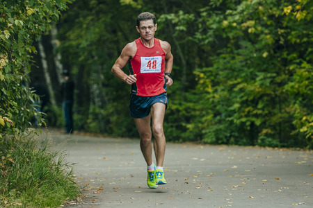 Chelyabinsk, Russia - September 6, 2015: middle-aged athlete runs through the Park during...