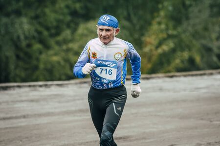 Omsk, Russia -  September 20, 2015: elderly man athlete runs along waterfront during Siberian international marathonのeditorial素材