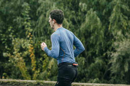 Omsk, Russia -  September 20, 2015: athlete runner runs along green trees during Siberian international marathonのeditorial素材