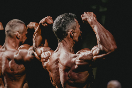 Chelyabinsk, Russia - October 3, 2015: male bodybuilder demonstrates biceps and back muscles during Championship of Chelyabinsk region on bodybuilding, bodyfitness and fitnessのeditorial素材