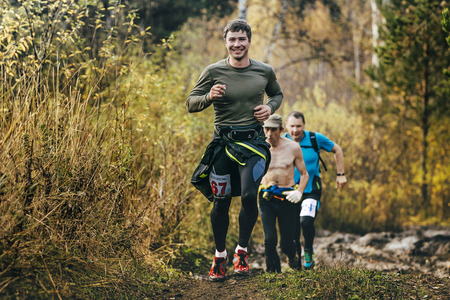 Beloretsk, Russia -  September 26, 2015: beautiful smiling man running in autumn forest during marathon mountain "Big Iremel"のeditorial素材