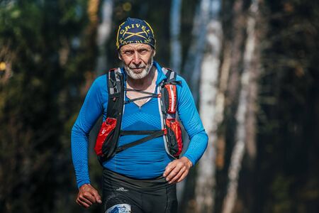 Beloretsk, Russia -  September 26, 2015: beautiful smiling senior man years running through woods during marathon mountain "Big Iremel"のeditorial素材