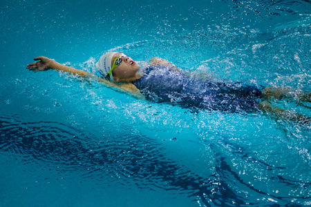 Chelyabinsk, Russia - October 21, 2015: young charming girl swims backstroke during Championship of...