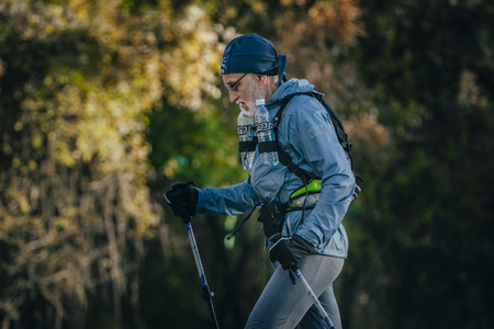 Yalta, Russia - October 31, 2015: old athlete is distance of race, with a backpack and water bottles during First Yalta mountain marathonのeditorial素材