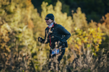 Yalta, Russia - October 31, 2015: young smiling man running in autumn forest during First Yalta mountain marathonのeditorial素材