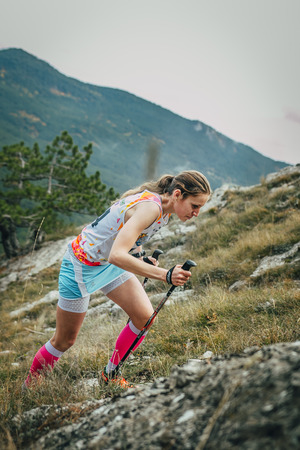 Yalta, Russia - November 2, 2015: girl athlete with walking sticks going uphill during Mountain marathon "Vertical kilometre AI-Petri"のeditorial素材