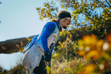 Yalta, Russia - November 4, 2015: closeup of young male athlete in headband and glasses. autumn landscape during mountain marathon Taurisのeditorial素材