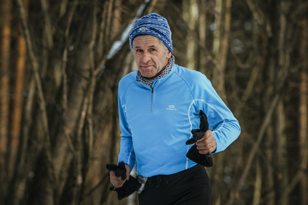 Ekaterinburg, Russia - November 14, 2015: closeup face old athlete running in winter Park in cold weather during Urban winter marathonのeditorial素材