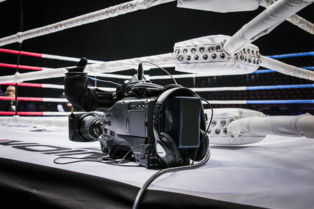professional camcorder stands on corner ring for mixed martial arts. live broadcast competition in...