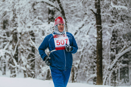 Chelyabinsk, Russia -  January 5, 2016: closeup male athlete senior years running in winter woods during Chelyabinsk winter marathonのeditorial素材