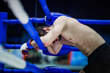 loser of fight boxer on ropes of corner ring after fight