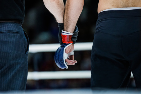 judge holds hand of  boxer before announcing winners in a fightの写真素材