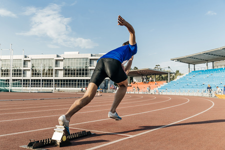 explosive start men runner at stadium during competitionの写真素材
