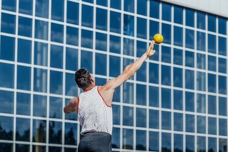 man athlete shot put at competition from backの写真素材