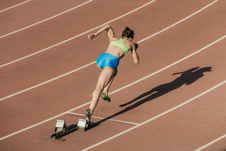 start women athletes from starting blocks in stadiumの写真素材