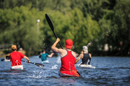 group of athletes canoeists boating on  lake in a kayak. water spray from oarsの写真素材