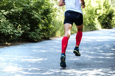 back view of running young male athlete during marathon