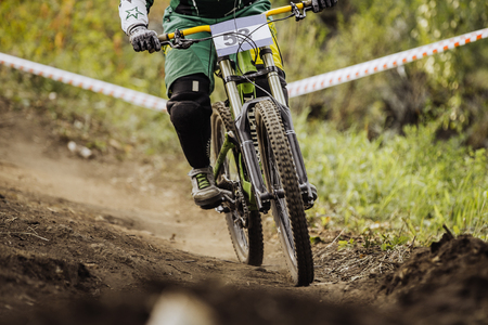 racer on bike rides forest trail during race downhillのeditorial素材