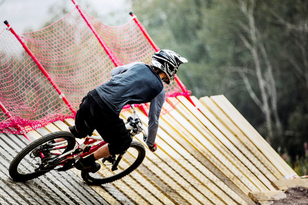 athlete man extreme cyclist riding Insloped Turn during competitions in downhillの写真素材