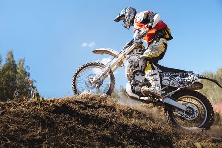 Kyshtym, Russia - July 17, 2016: athlete racer on a motorcycle rides up hill on a dusty track during Ural Cup in Enduroのeditorial素材