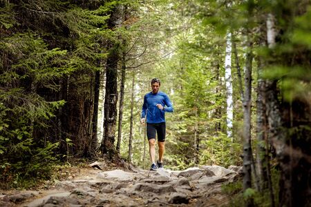 Zlatoust, Russia - August 28, 2016: young male athlete active runs rocks trail in woods during...