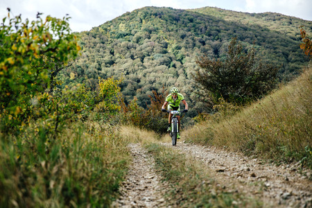 male rider cyclist riding uphill on a forest trail during Crimean race mountainbikeのeditorial素材