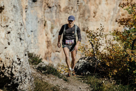 middle-aged man runs on a trail with running backpack during Crimea mountain marathonのeditorial素材