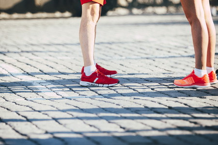 feet young man and woman in running shoes on city streetの写真素材