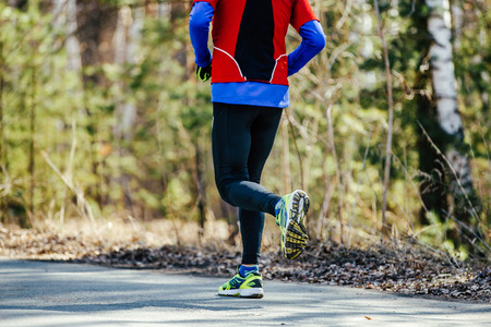 real athletic runner man running asphalt road in city park
