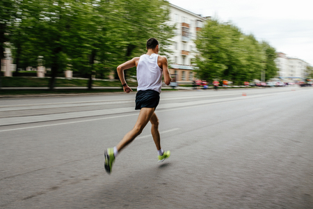 blurred motion runner man running on city streetの写真素材