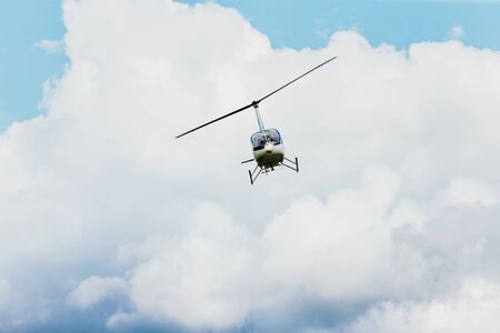helicopter flying in blue sky and cloudsの写真素材
