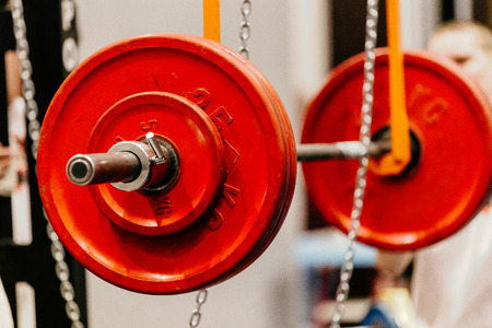 barbell with red plates for squats on monolift in gymの写真素材