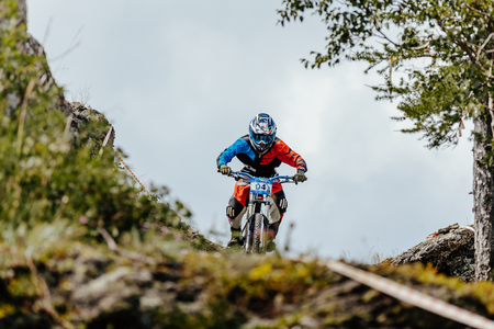 Magnitogorsk, Russia - July 21, 2017: man rider downhill bicycle on a mountain trail during National championship downhillのeditorial素材