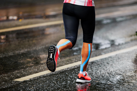 blue kinesio tape on calf muscle women runnerの写真素材
