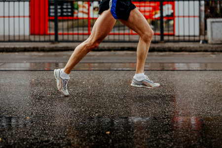 foot men runner running on wet from rain gray asphaltの写真素材