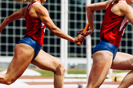 relay race passing of baton women team runnersの写真素材