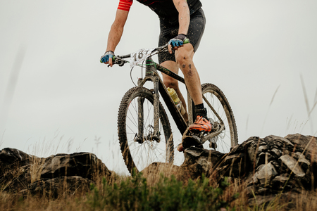 dirty athlete cyclist on mountain bike biking on mountain stone trailの写真素材