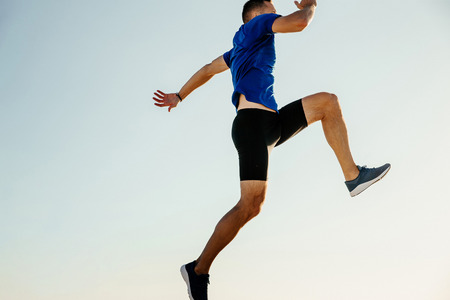 male athlete jumping on blue sky background. freedom conceptの写真素材