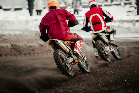 two riders enduro motorbike riding on winter trackの写真素材