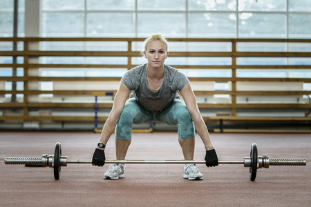 female athlete doing exercise deadlift barbell in gymの写真素材
