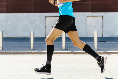 legs runner man in black compression socks running streetの写真素材